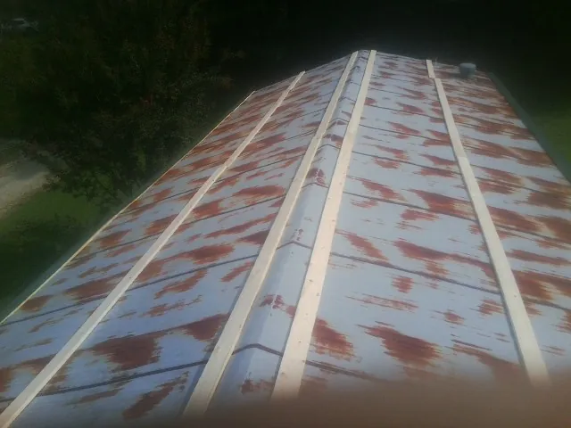 Rusted metal roof panels with new wood purlins before replacement — Storm Damage Roof Repair in Doerun by Roofing Brothers