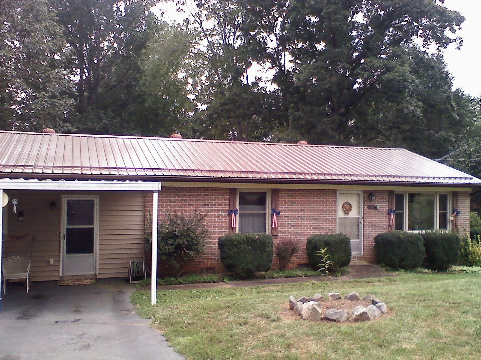 Bronze metal roof and carport on a brick ranch home — Roof Repair work by our crew in Doerun